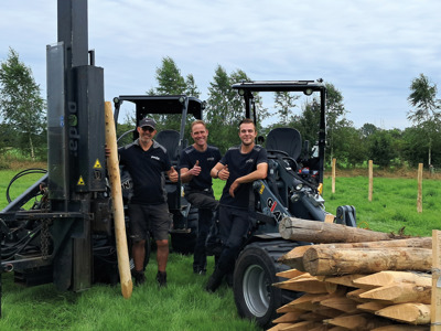 Drie omheiningsmonteurs tijdens het plaatsen van een omheining met machines.