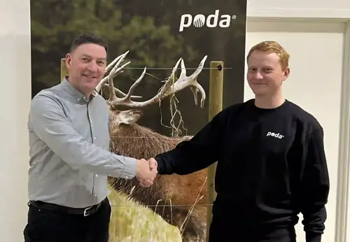 Poda-directeur Peter schudt de hand van Sofus van Poda Hegn Ringe, voor een banner met een edelhert en schrikdraad.